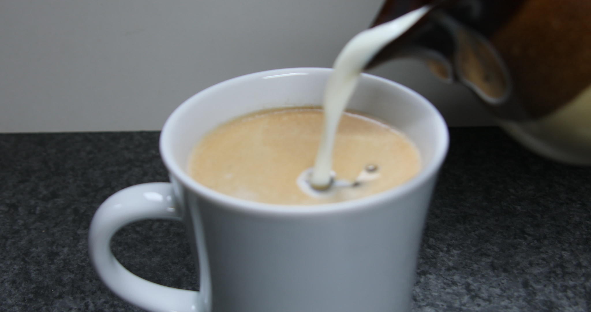 牛奶壶倒入咖啡杯中视频的预览图