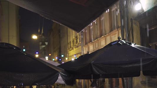 夜里大雨中的户外街头咖啡馆的雨滴从树冠上掉了下来灯笼挂灯笼上视频的预览图