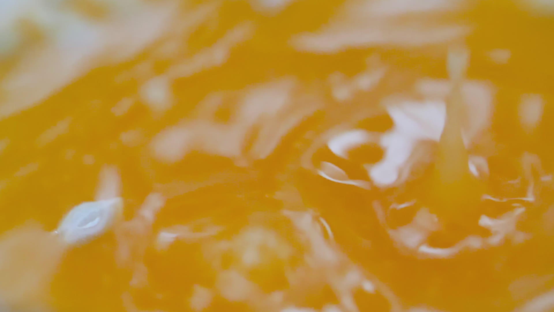 缓慢运动的橙汁滴落和喷洒视频的预览图