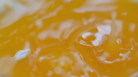 缓慢运动的橙汁滴落和喷洒视频的预览图