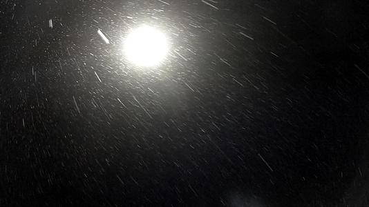 冬天的夜雪在街道灯光下缓慢移动视频的预览图