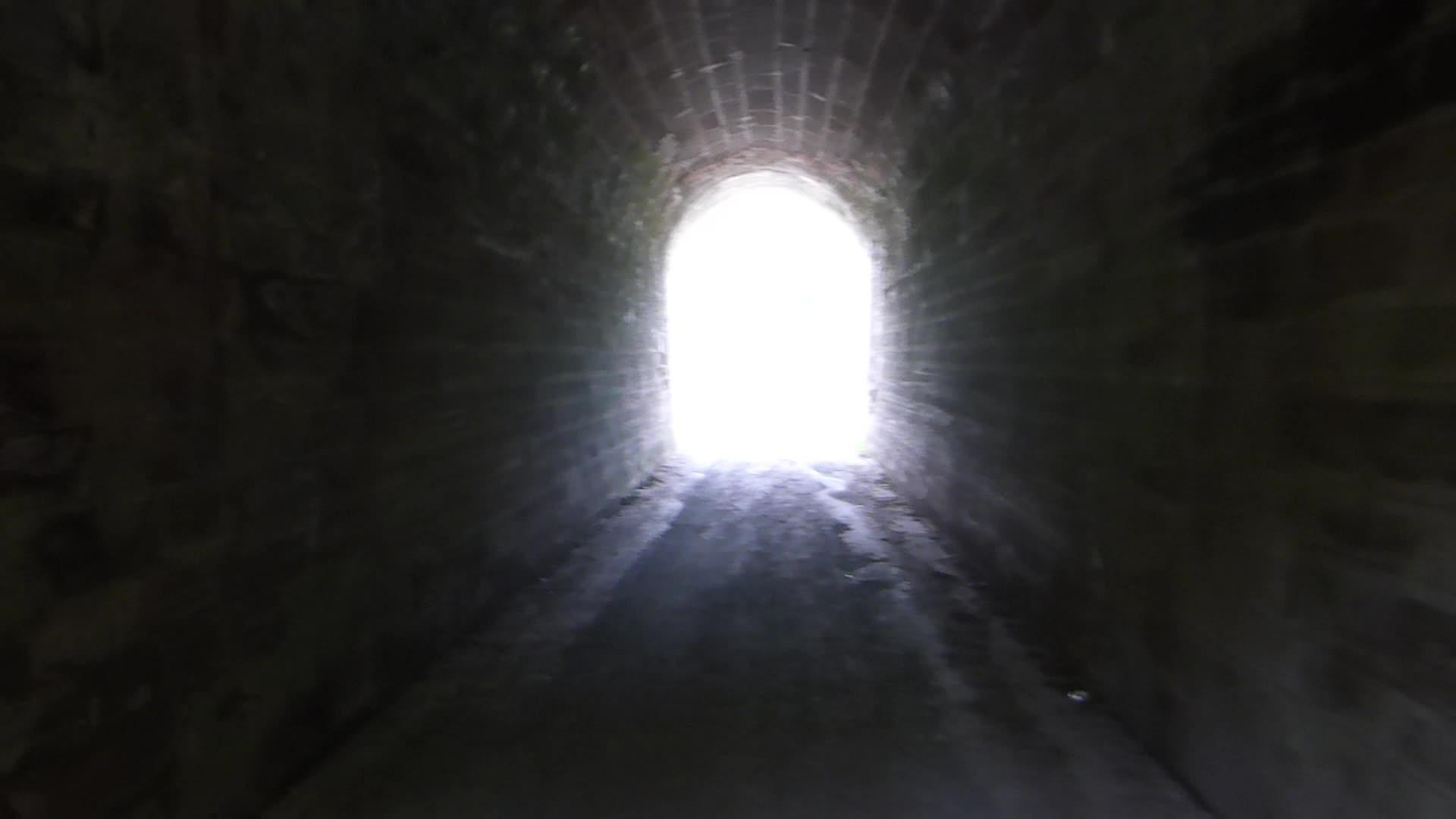 在黑暗隧道中行走的尽头有灯光视频的预览图