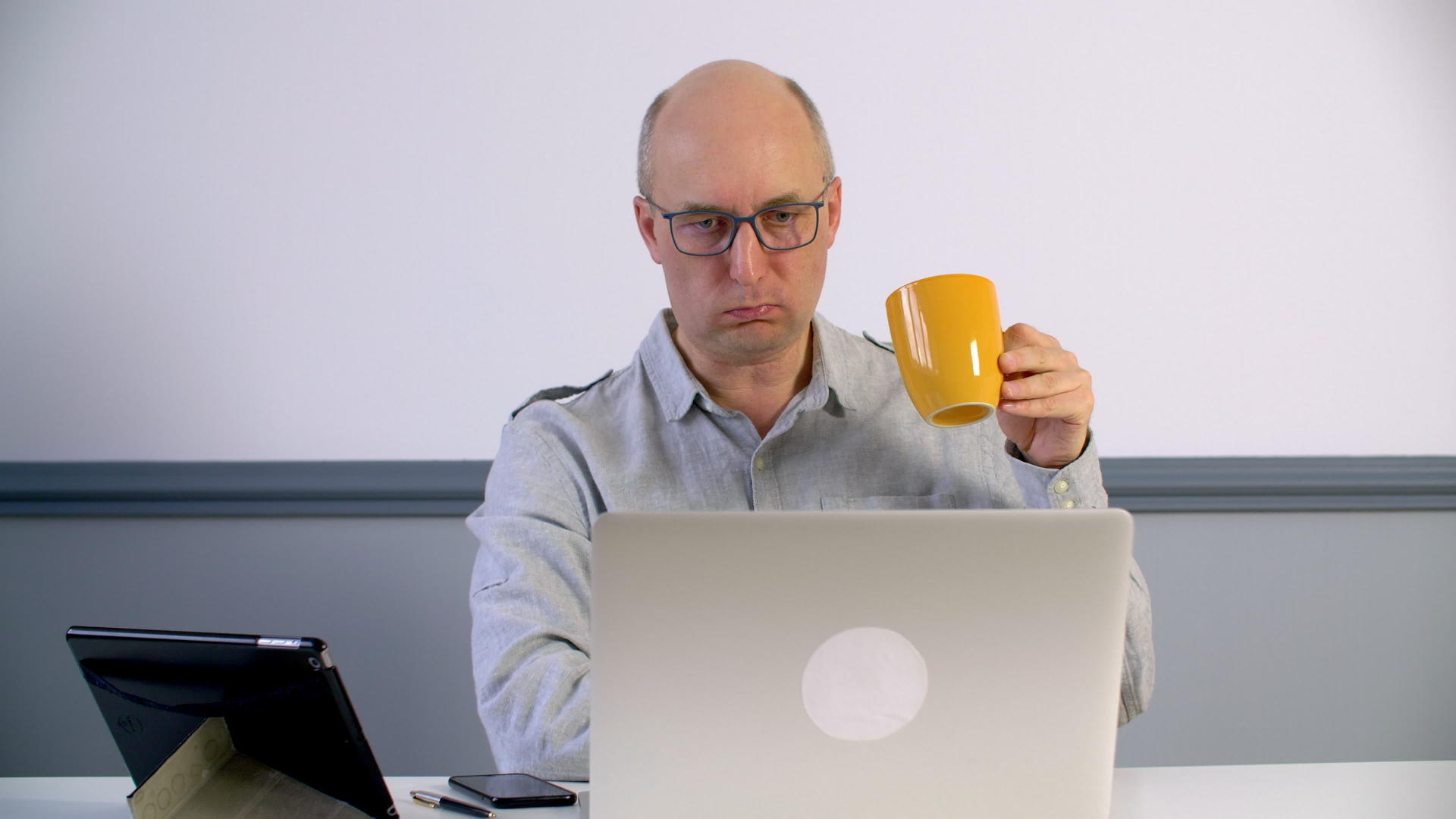 成年男子在看笔记本电脑时喝咖啡视频的预览图