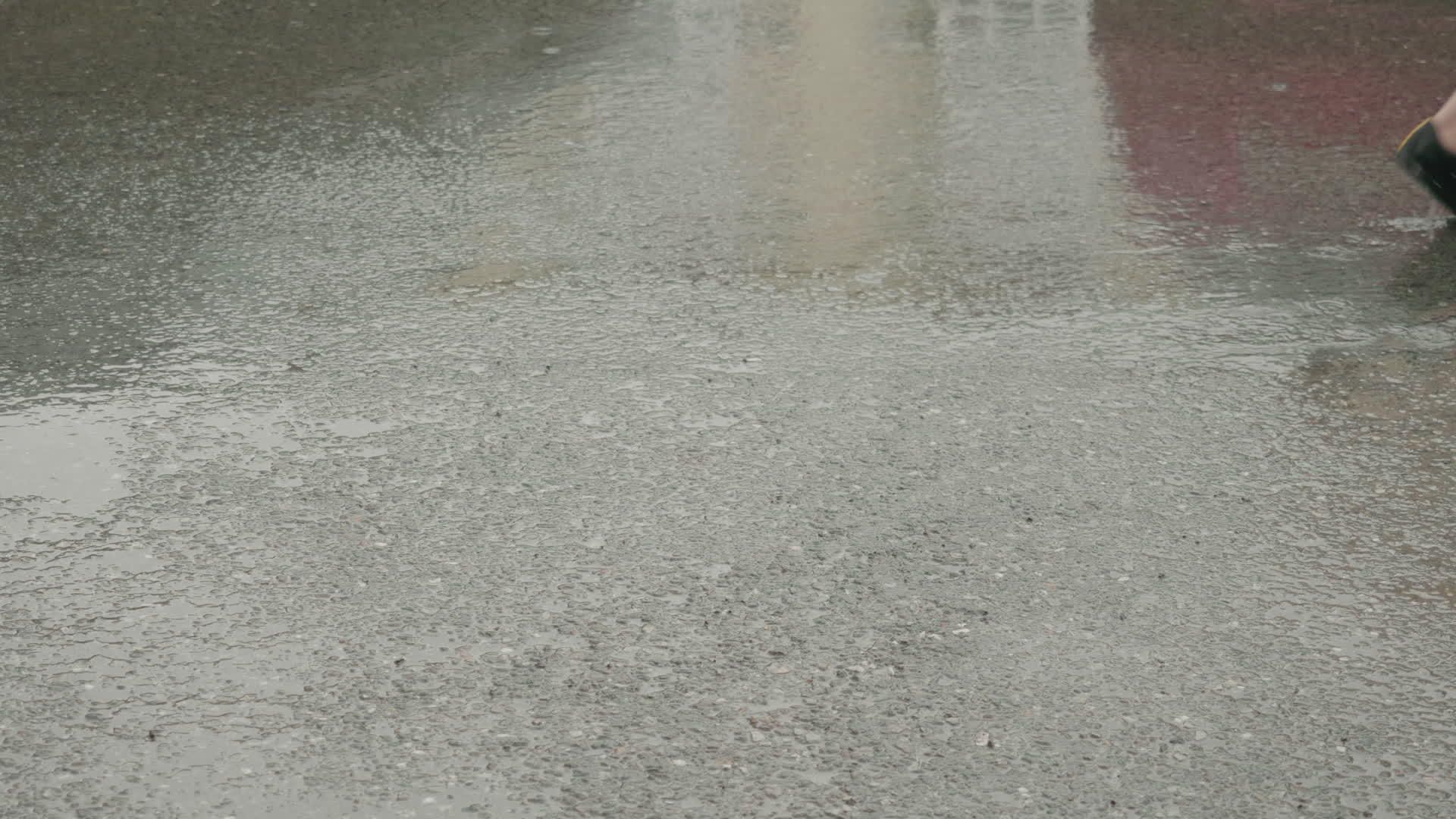女孩和男孩的腿在路边灰色潮湿的雨中行走视频的预览图