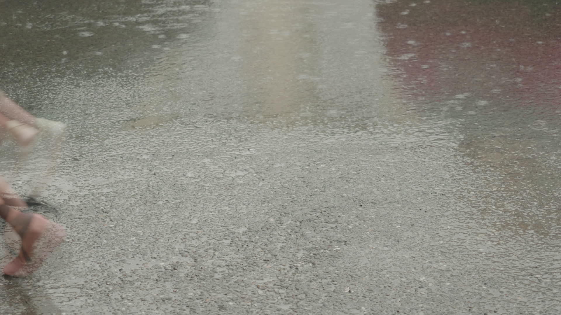 在城市街道上女人的腿在夏天的雨中行走两个女人在柏油路上下雨视频的预览图