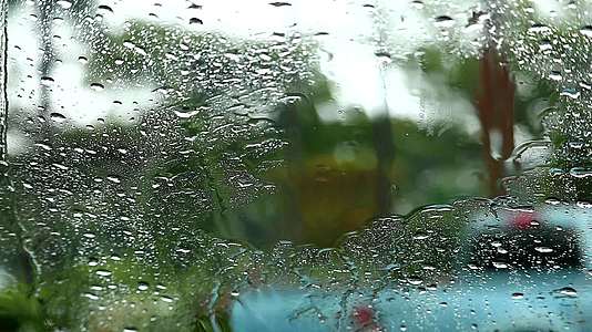 照镜子的雨滴在汽车和白色汽车上右转在公园里模糊树木视频的预览图