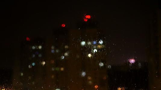晚上雨水从玻璃上流下来闪电滚动视频的预览图