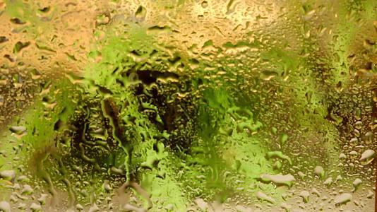窗户玻璃上的雨滴模糊背景视频的预览图