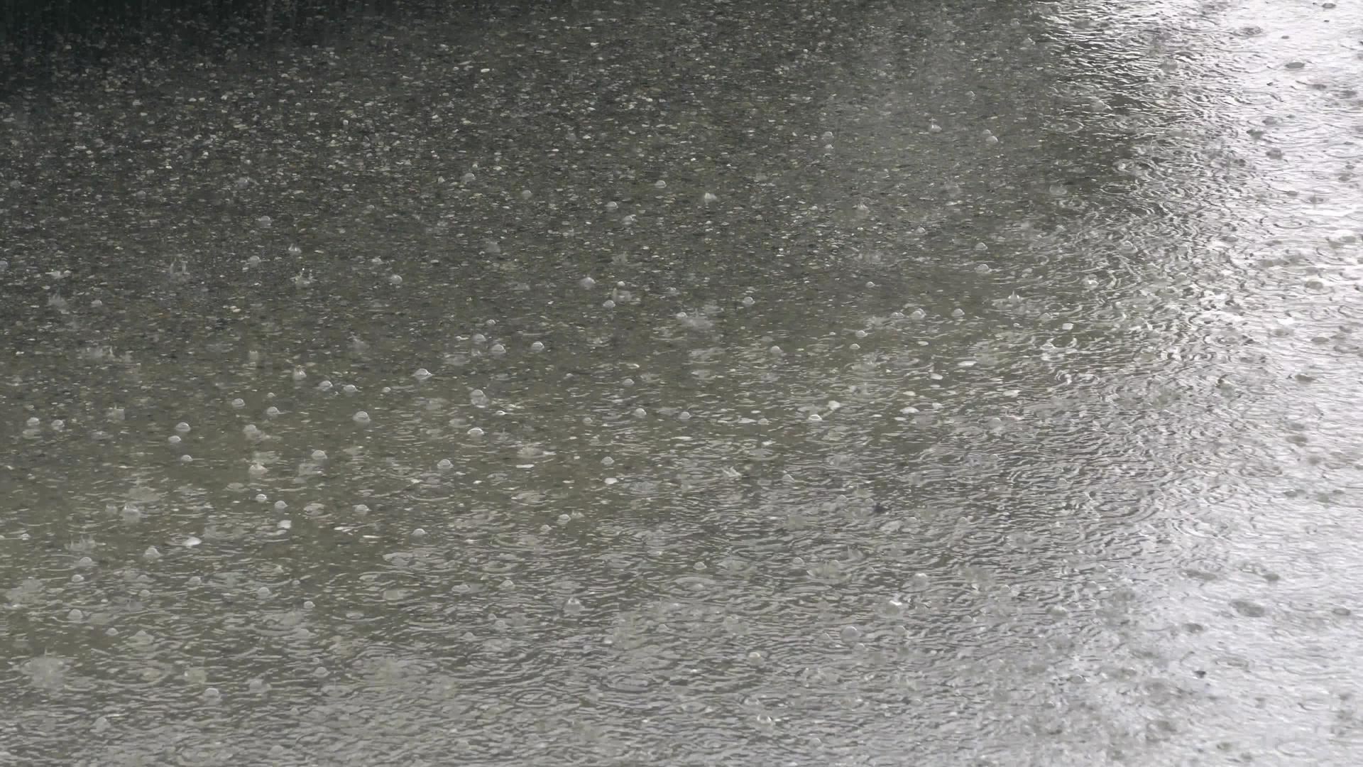 沥青路的一个水坑里有雨点视频的预览图
