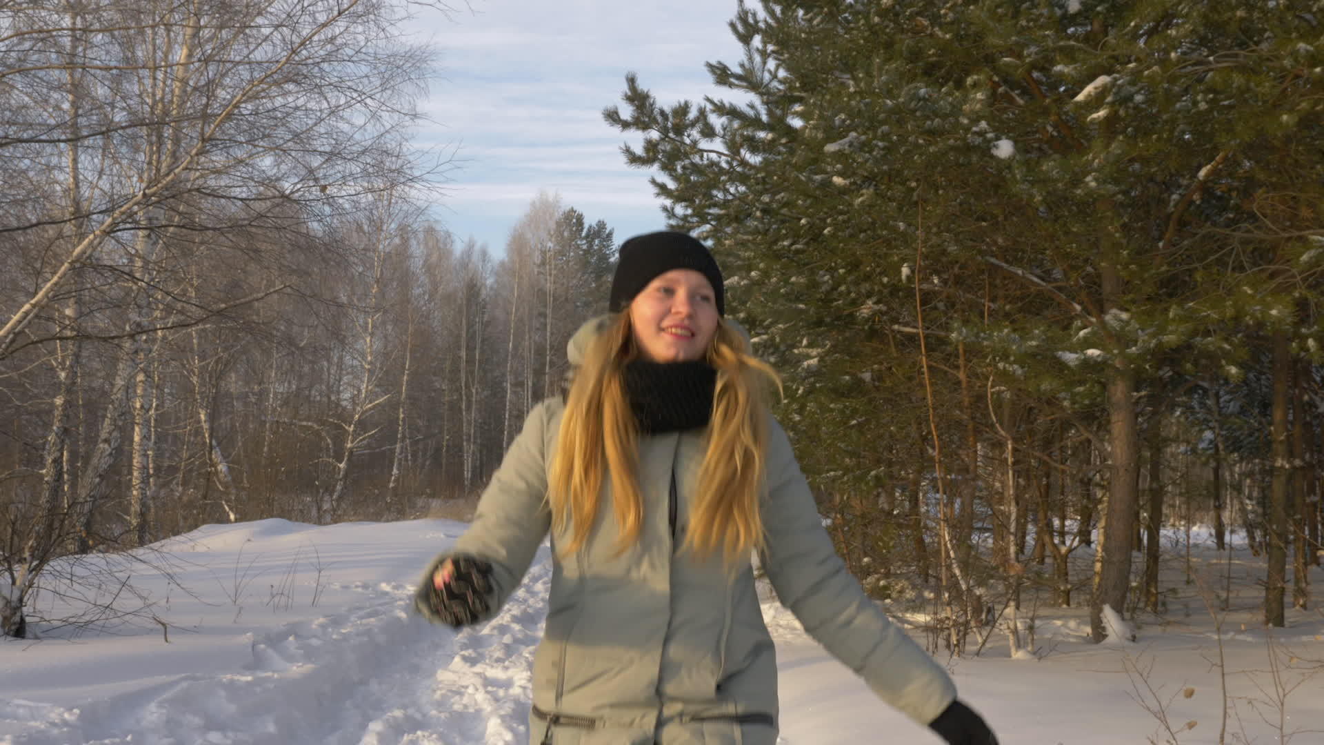 穿着夹克在雪地里散步在冬天的森林里跳跃和玩耍年轻而美丽视频的预览图