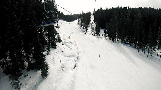雪林和滑雪者在滑雪电梯上观察慢动作视频的预览图