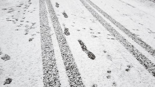 路上新雪上的脚印和轮胎脚印视频的预览图