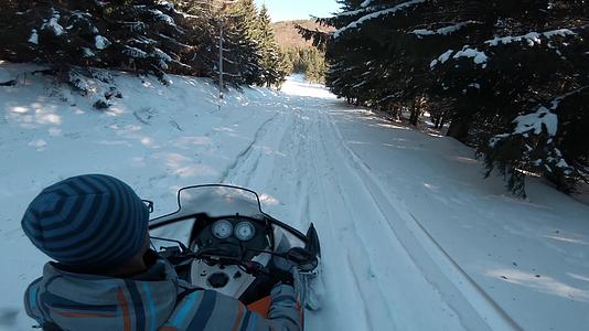 雪地摩托驾驶冬季森林骑雪地摩托寒假自然休闲理念视频的预览图