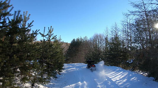 在美丽的冬天在森林深雪中一个年轻人在雪地里开车视频的预览图