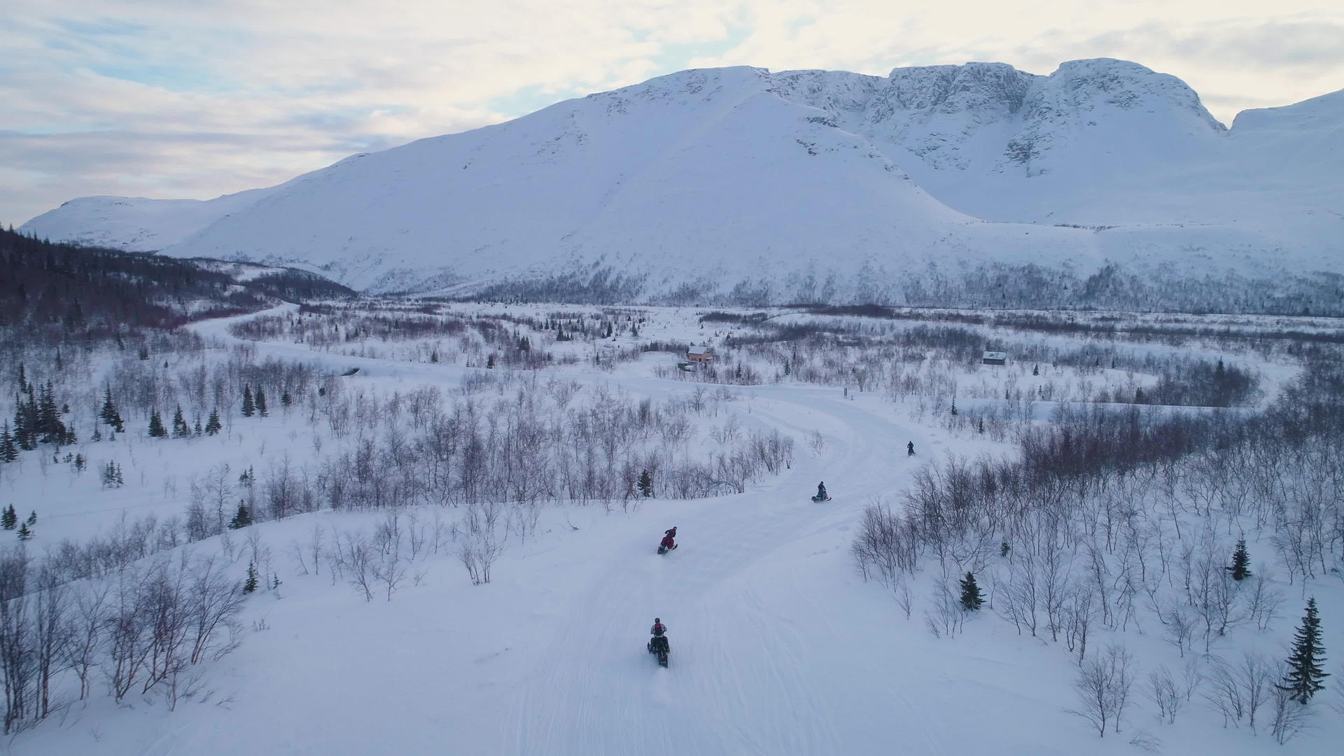 在雪山上骑着雪车在空中观察无人驾驶飞机正在追逐雪地移动视频的预览图