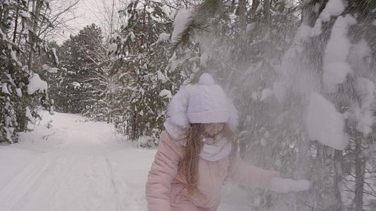 女孩从松枝上打雪视频的预览图