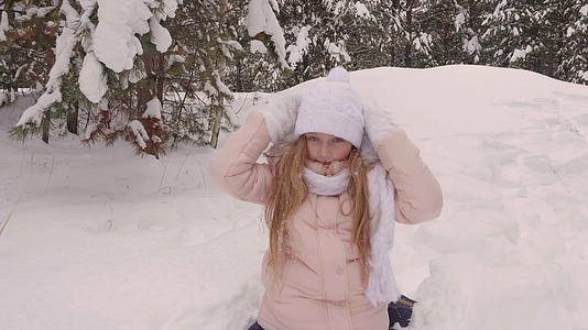 冬天的森林里快乐的女孩在无知的树林背景下下雪视频的预览图
