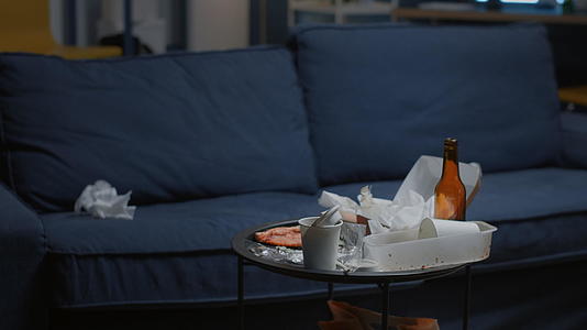 在一个空荡荡的客厅里桌子上有剩菜和啤酒瓶视频的预览图