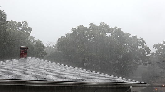 暴雨往往在夏天从房子屋顶流到城市山顶视频的预览图