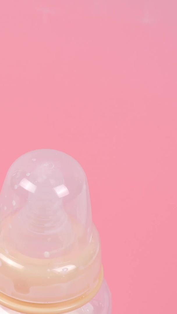 粉红色背景的婴儿鞋和可爱的小瓶子组合视频的预览图