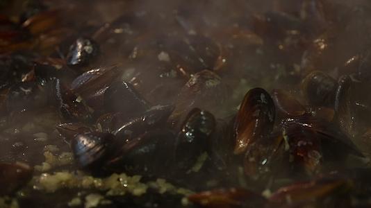 在大煎锅做饭搅拌贝类视频的预览图