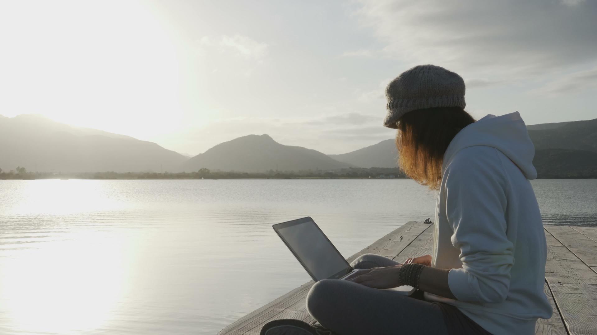 一位年轻女子日落时坐在湖边视频的预览图