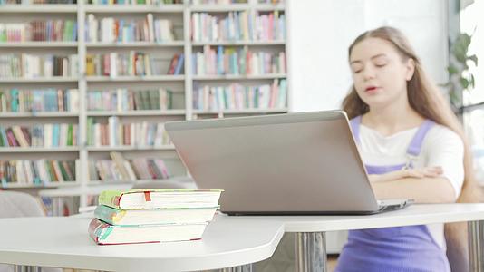 在背景中使用笔记本电脑的女孩书籍中选择关键点视频的预览图
