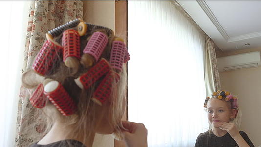 卷发的年轻女孩用棉质海绵前镜化妆视频的预览图