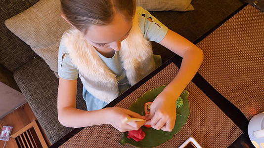 女孩在亚西餐厅顶楼吃日本寿司卷和筷子视频的预览图