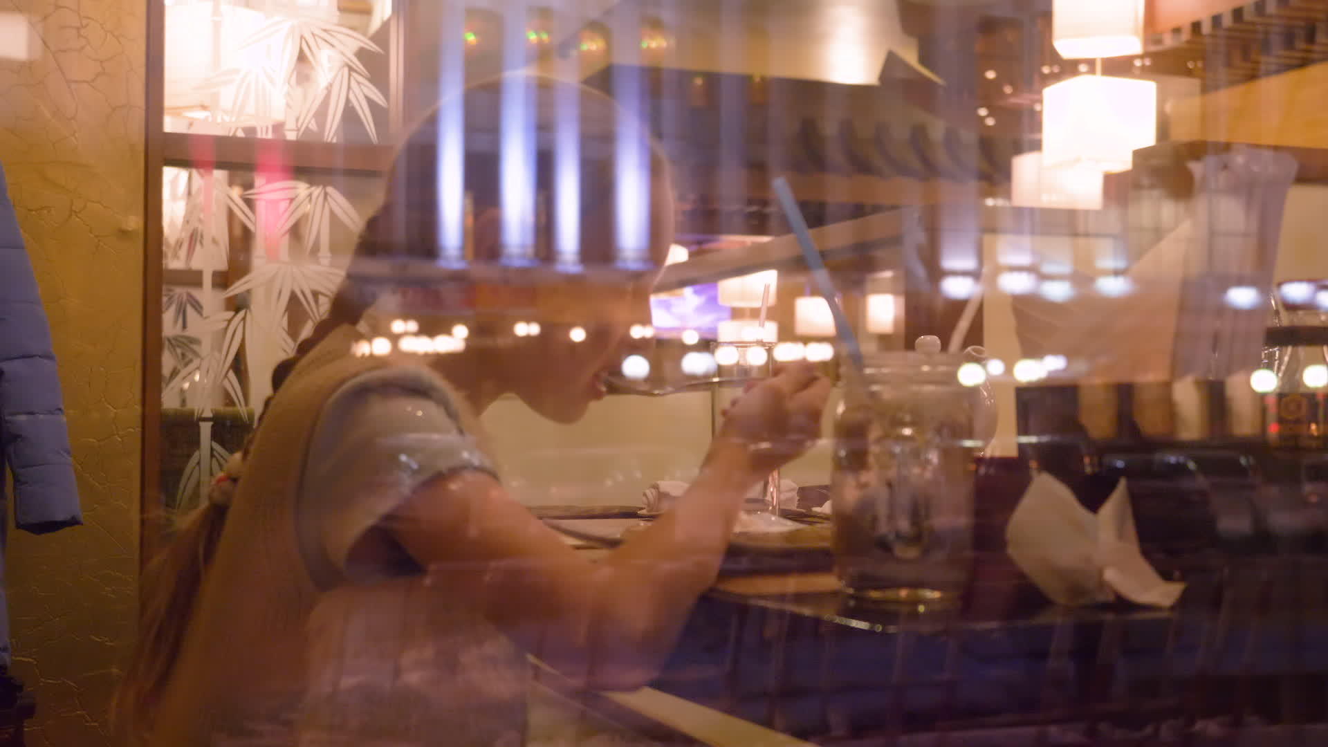 在咖啡馆桌边吃冰淇淋的女孩窗玻璃后面看风景视频的预览图