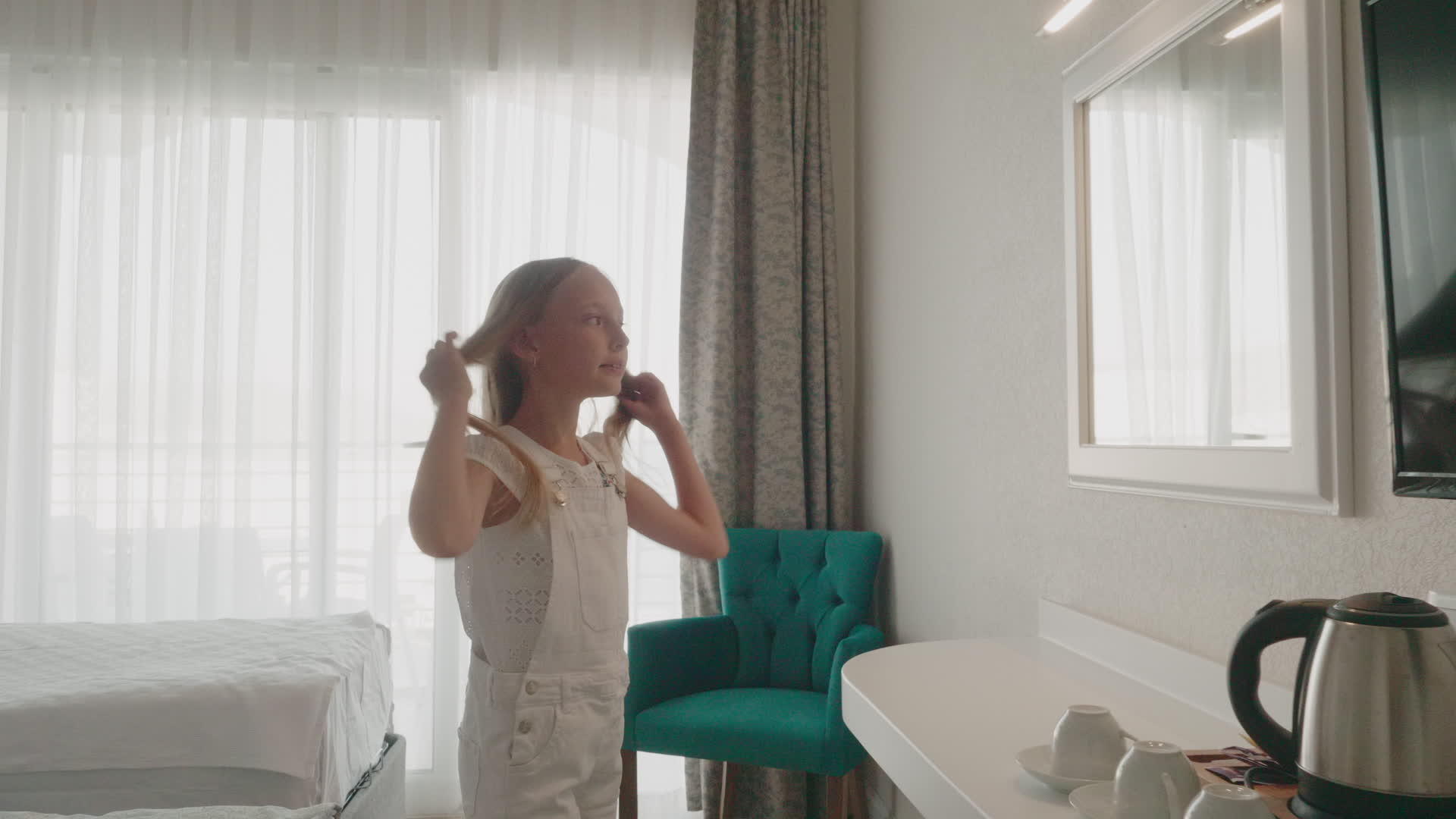 十几岁的女孩在白色设计中玩得很开心小女孩在卧室镜子前视频的预览图