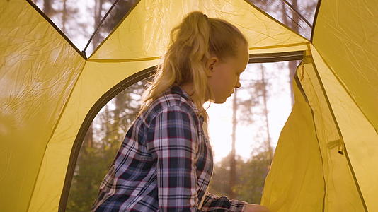 年轻女孩打开露营帐篷窗口视频的预览图