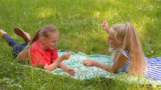 一个开朗的女孩躺在夏天的草地上有趣的女孩在夏天的一天视频的预览图