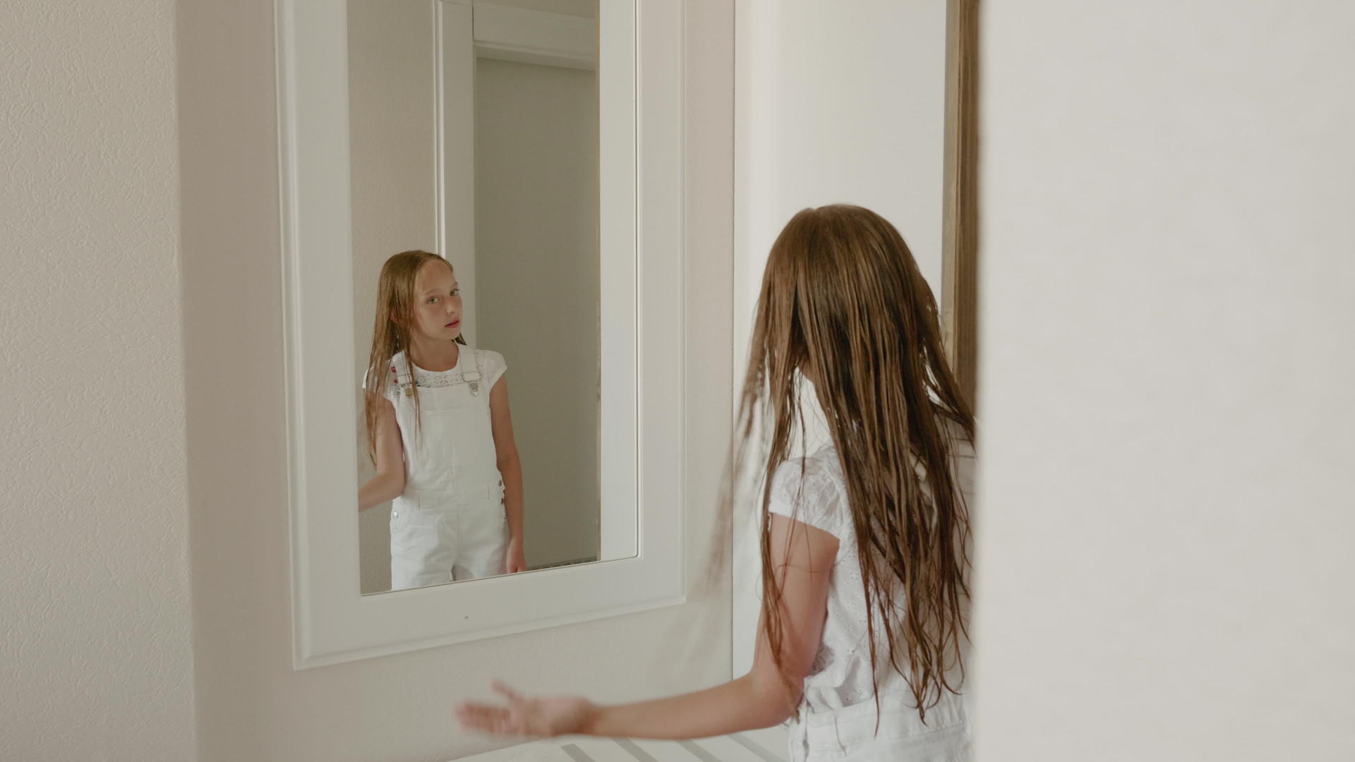 洗完澡后头发湿漉漉的年轻女孩在门后卫生间摆姿势视频的预览图