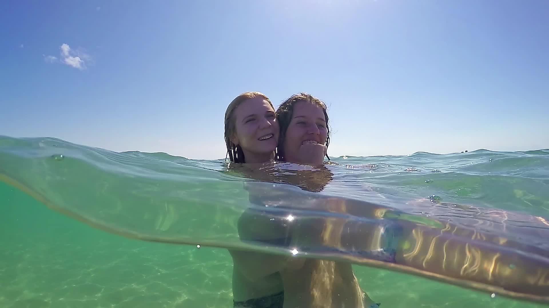 爱着两个女孩在海绿水中拥抱微笑Goprodome视频的预览图
