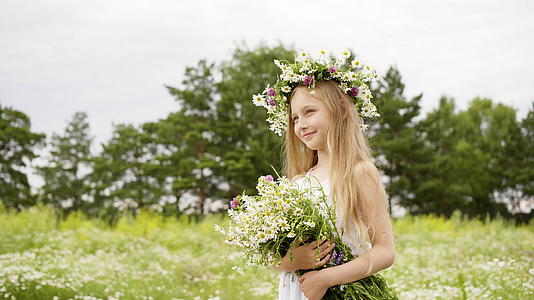 年轻女孩近视头上有花圈花束在花草地上视频的预览图