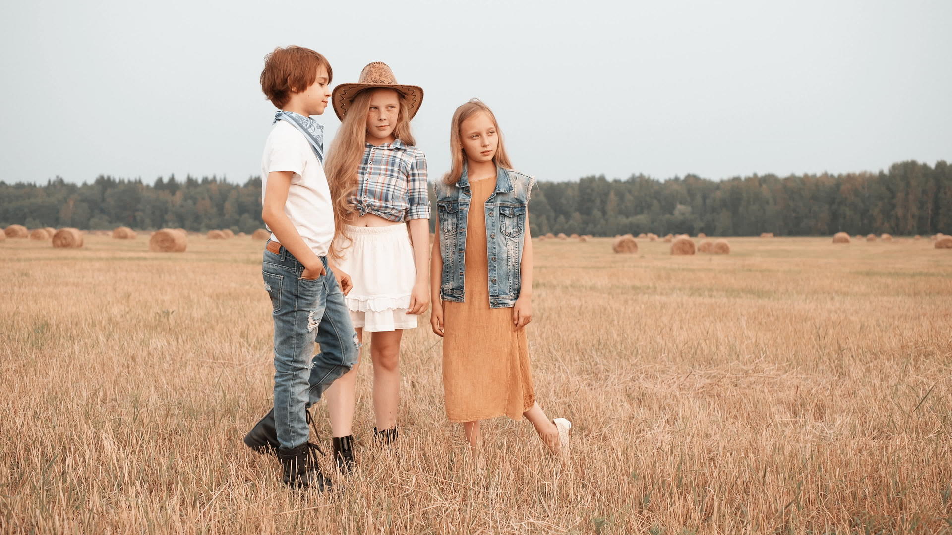 男孩和两个女孩在秋村的收割场上摆姿势而他们则站在田地里视频的预览图
