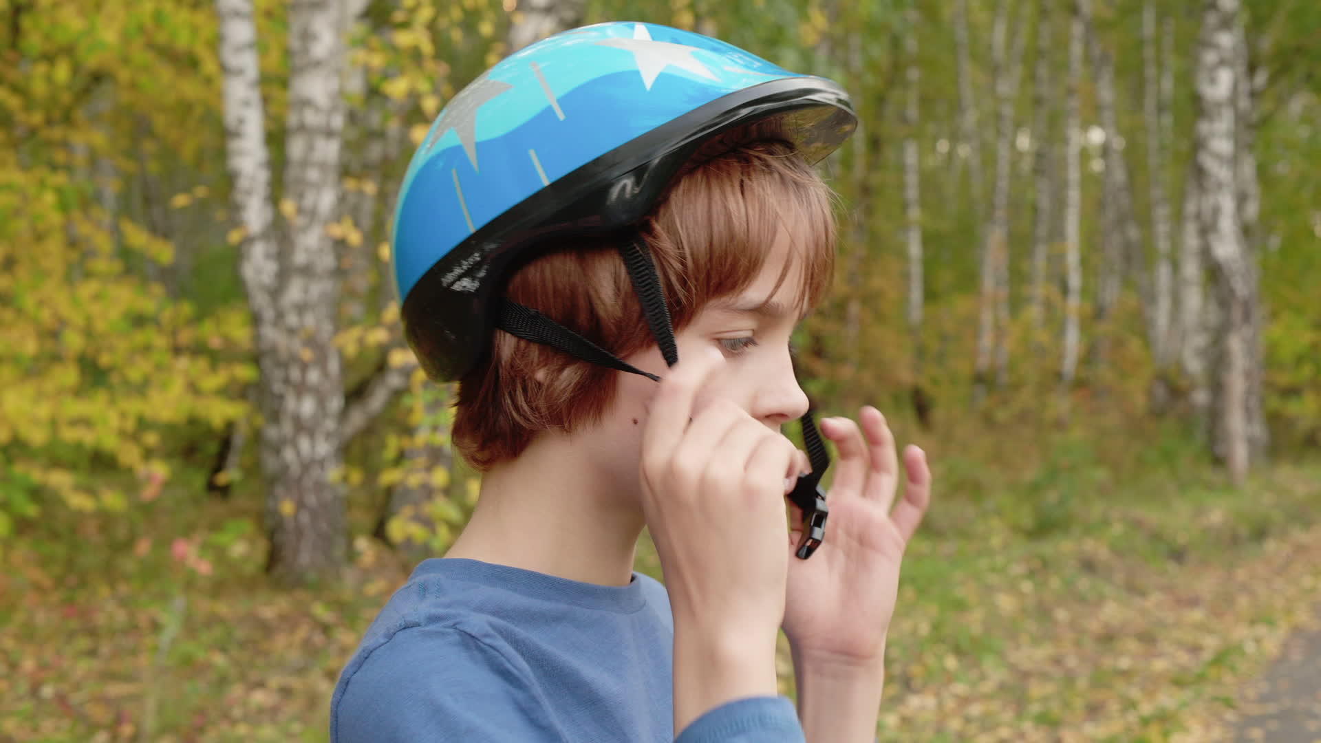 在秋天的公园里十几岁的男孩头上戴着自行车头盔视频的预览图