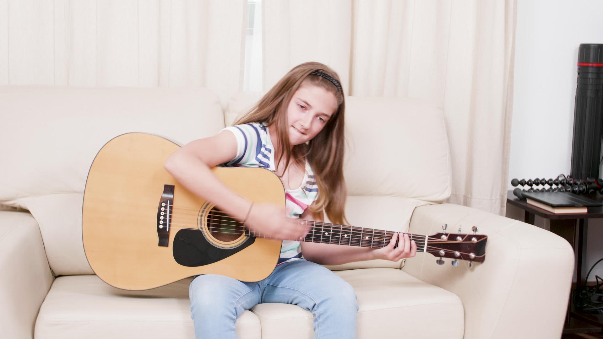 女孩在沙发上弹吉他坐在沙发上视频的预览图