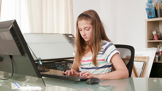 从事计算机工作和打字文本的年轻女孩视频的预览图