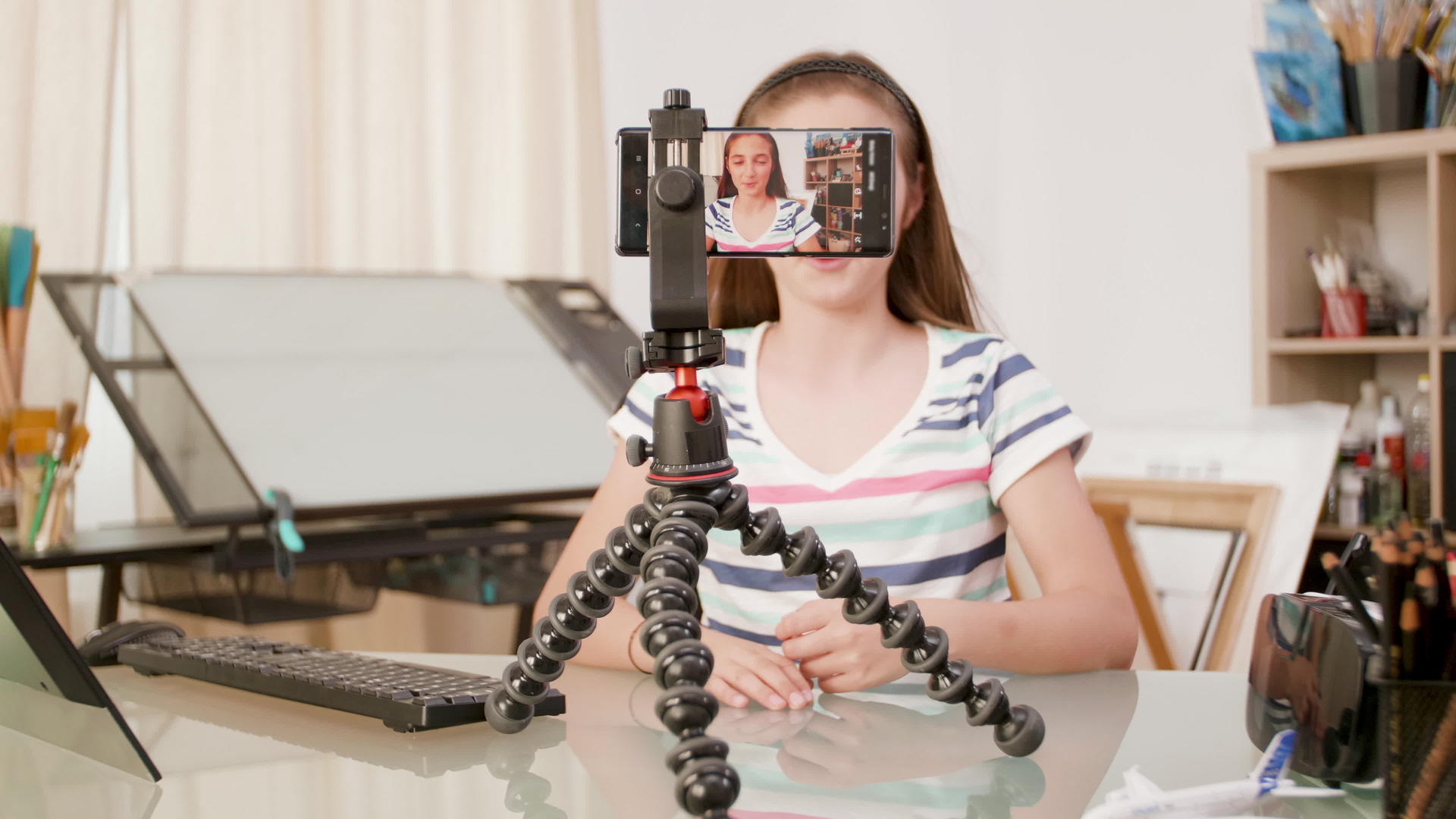 智能手机拍摄一个年轻女孩在三脚架上说话视频的预览图