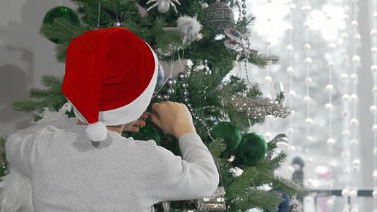 圣达克拉斯用圣达克拉斯帽子装饰圣诞树视频的预览图