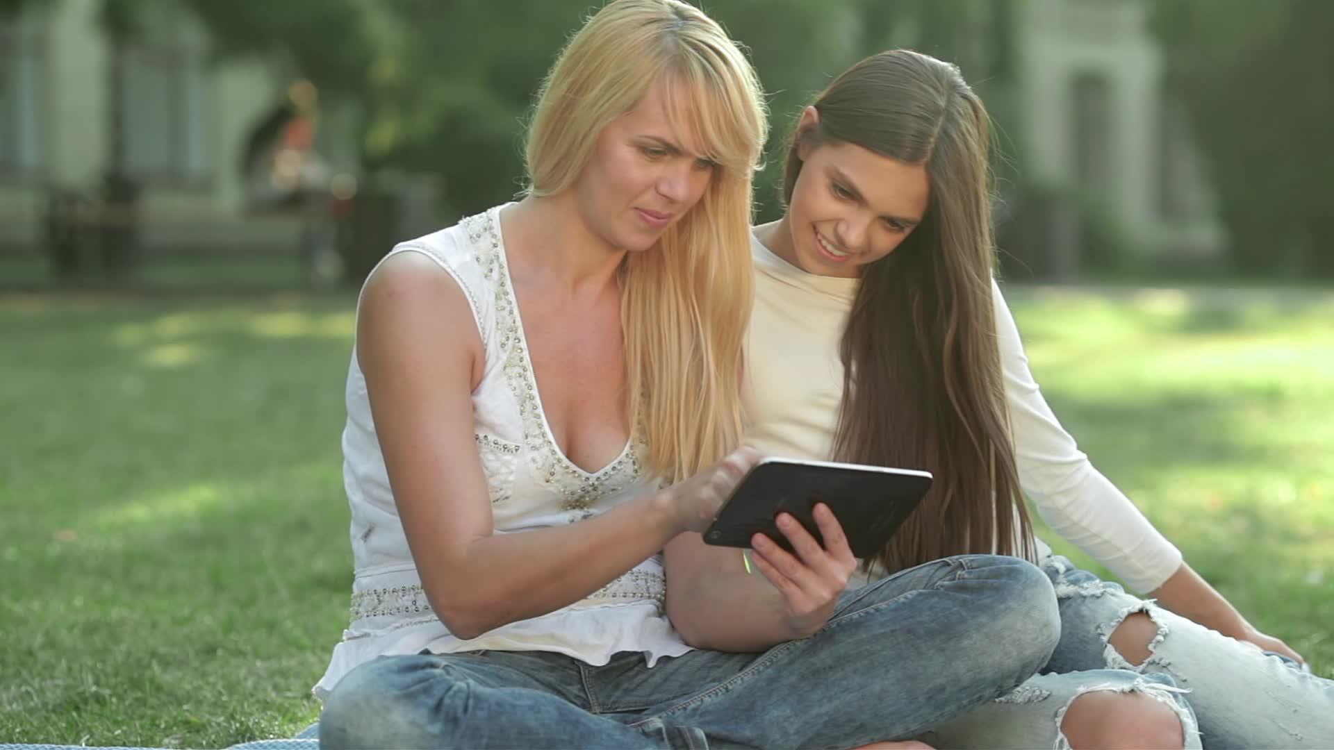 用平板电脑坐在草地上视频的预览图