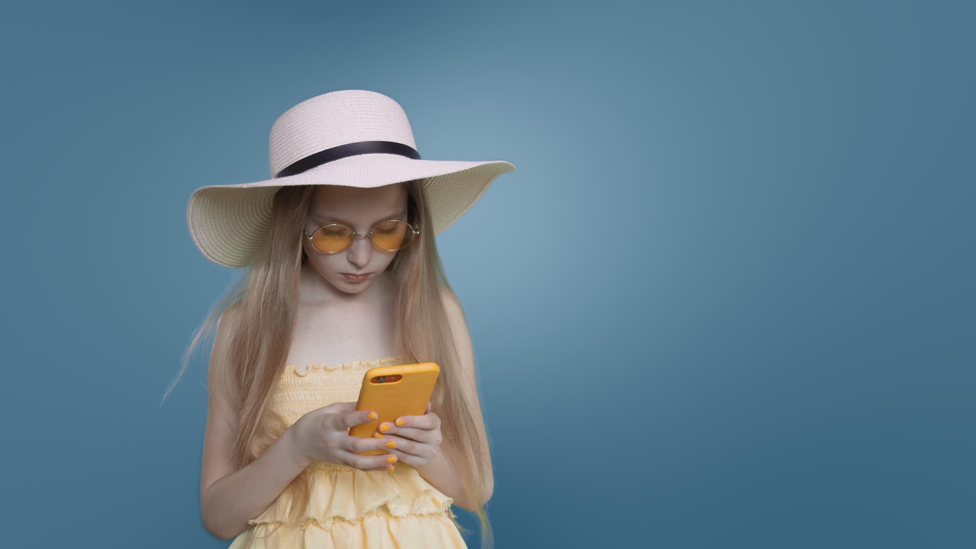 蓝色背景下女孩在蓝色背景下浏览手机视频的预览图