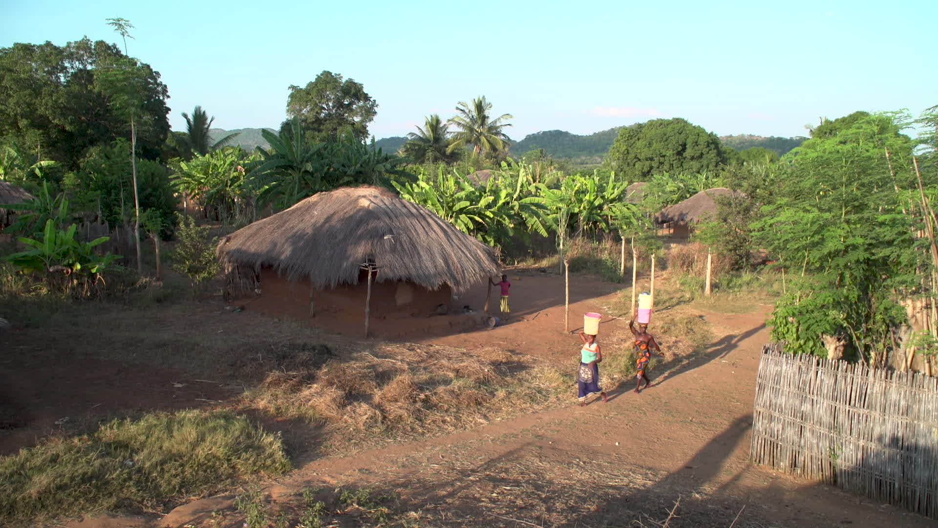 两名妇女穿过一个非洲村庄在水中行走视频的预览图