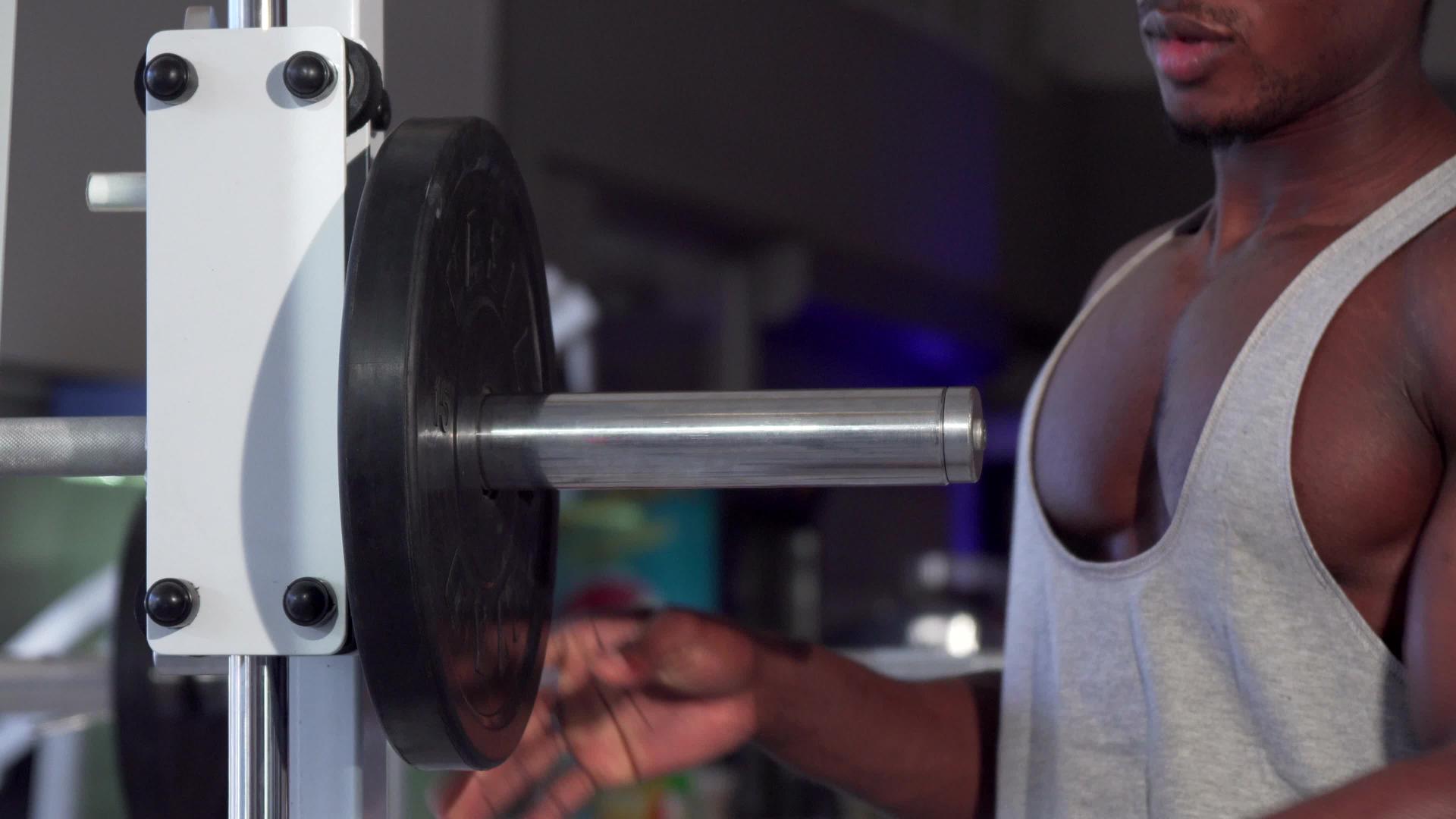 非洲人把重盘子放在巴铃上在健身房锻炼视频的预览图