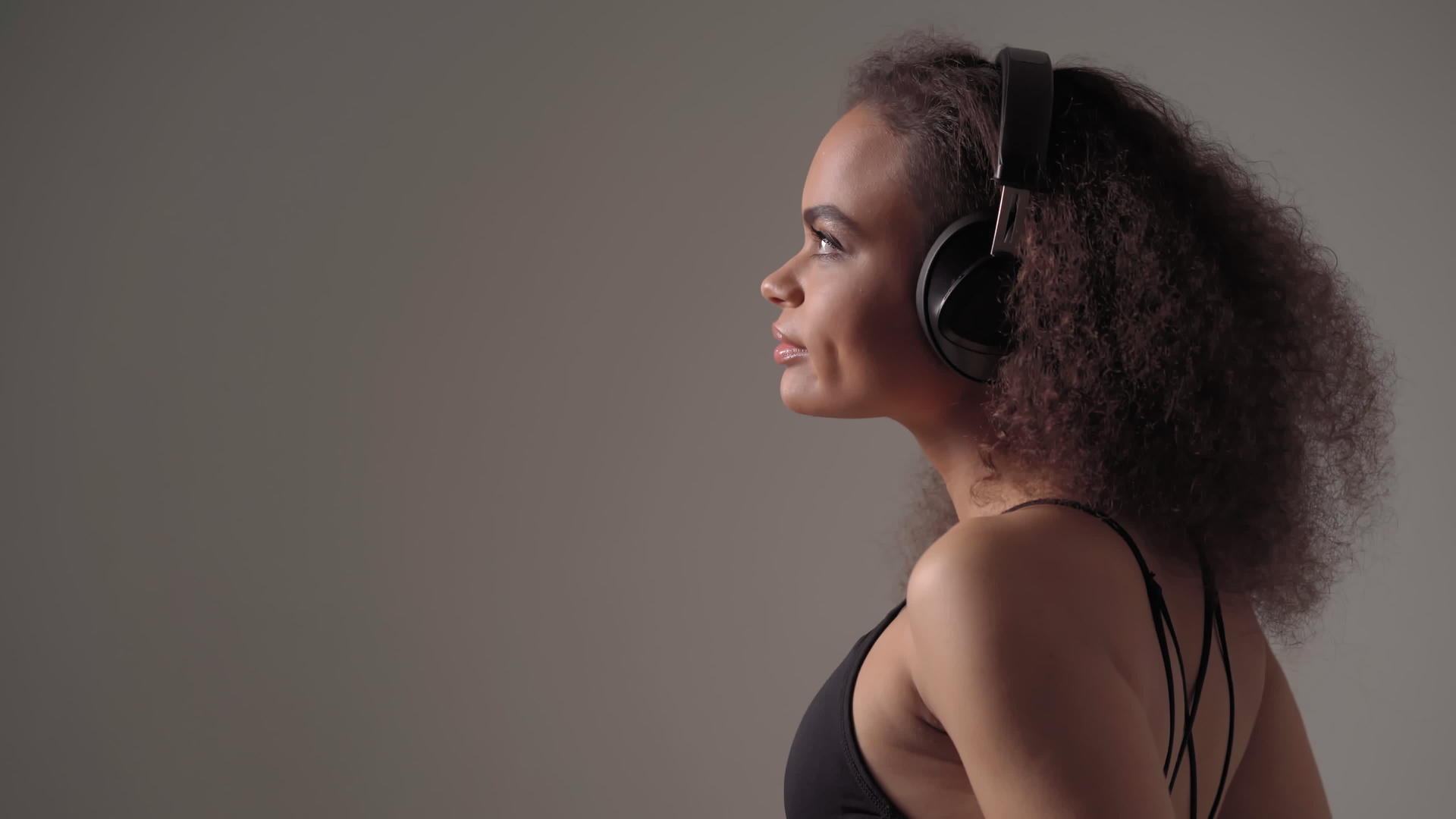戴着耳机的非裔美国女孩抬头听音乐闭上眼睛享受孤立视频的预览图