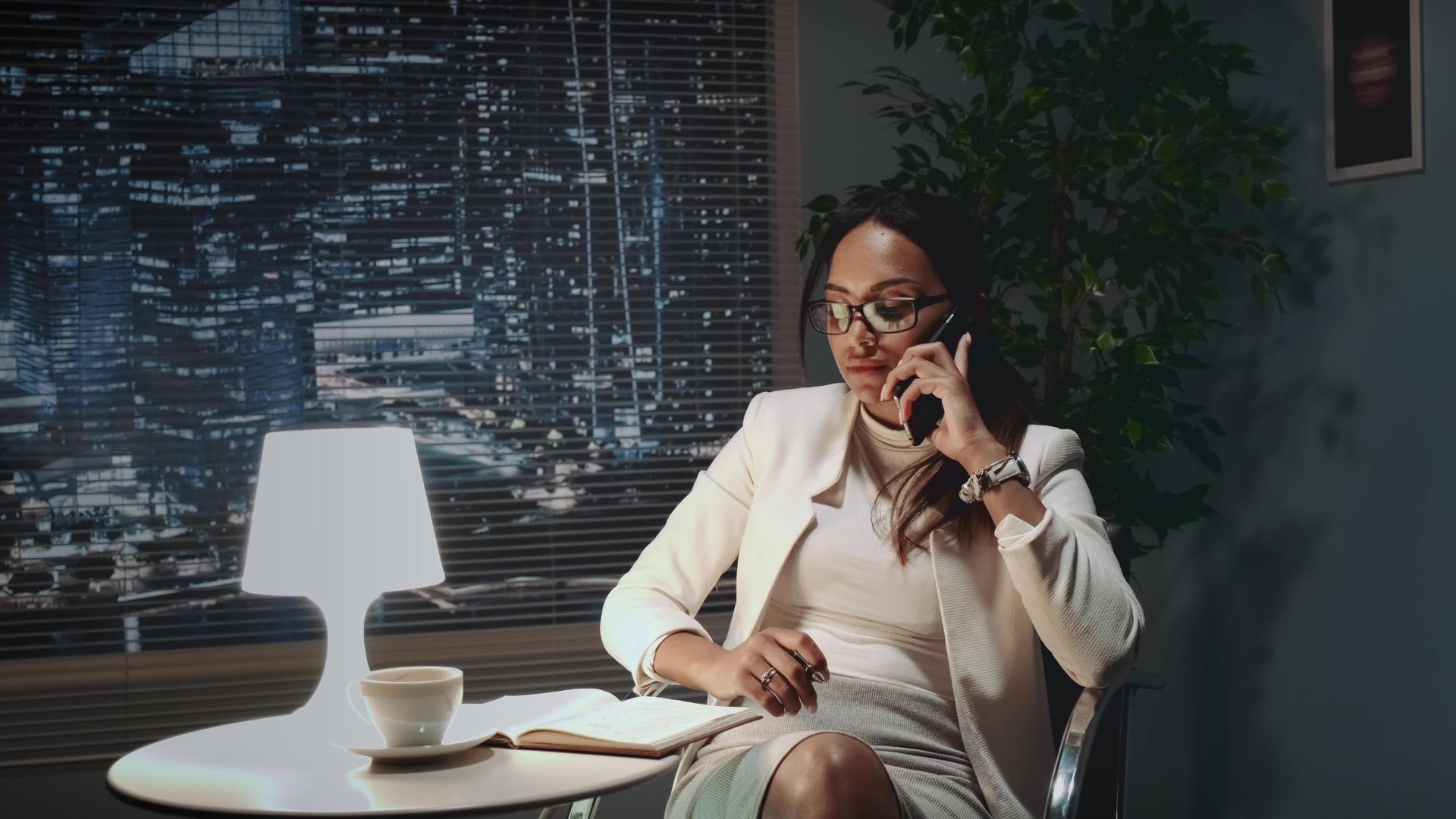 戴眼镜的非裔美国女商人用智能手机用什么话筒说话？视频的预览图