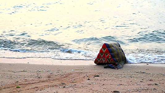 三角形枕头被扔进海里在海滩上被撞成废物和环境视频的预览图