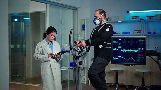 在体育科学实验室的交叉教练上运动员们戴着口罩跑步视频的预览图